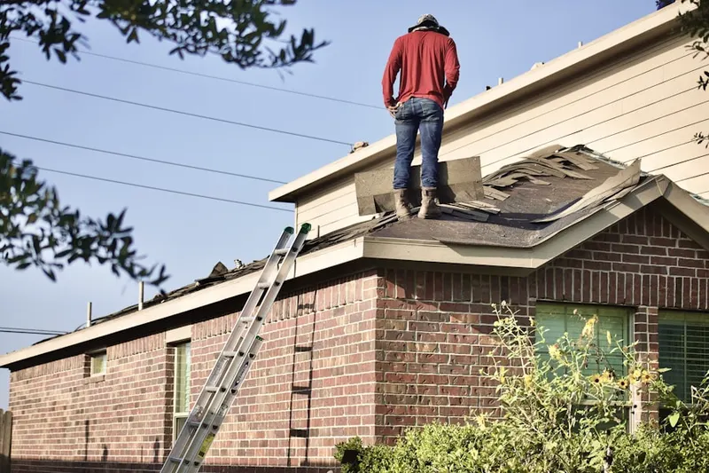 Professional roofer working on a residential roof in Patchwork Farms